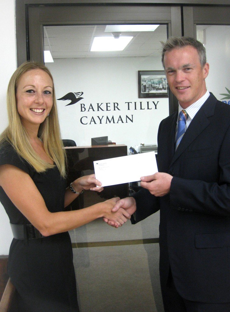 Connie Swart of Baker Tilly (Cayman) Ltd. presents Mr. Horton with the donation.